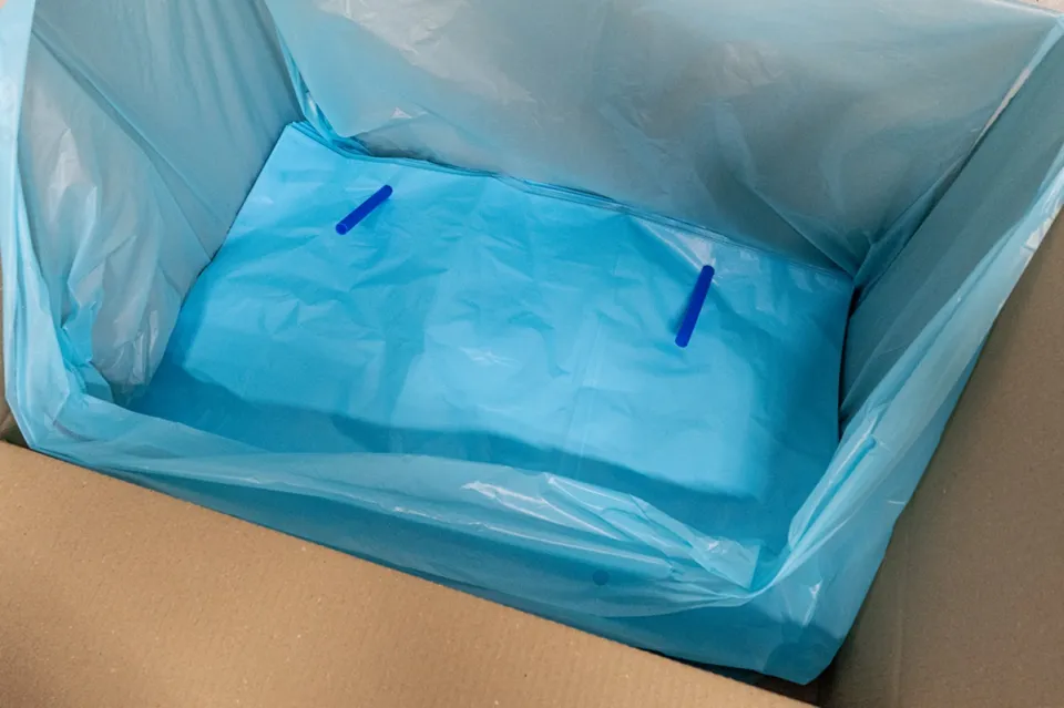 Kék polietilén bélelőzsák kartondobozban, műanyag hüvelyen